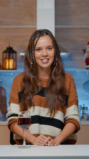 Foto portret van een glimlachende jonge vrouw die op tafel zit