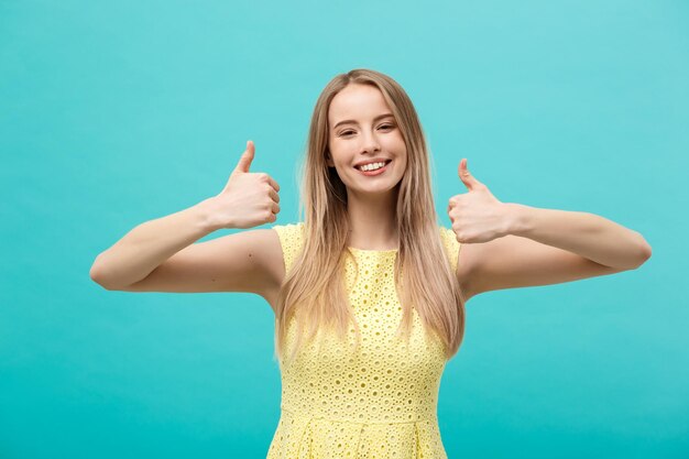 Portret van een glimlachende jonge vrouw die tegen de blauwe hemel staat