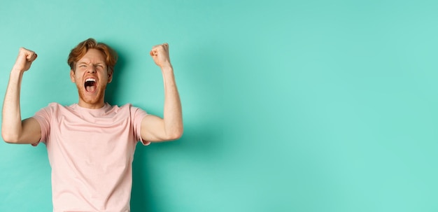 Foto portret van een glimlachende jonge vrouw die tegen een blauwe achtergrond staat