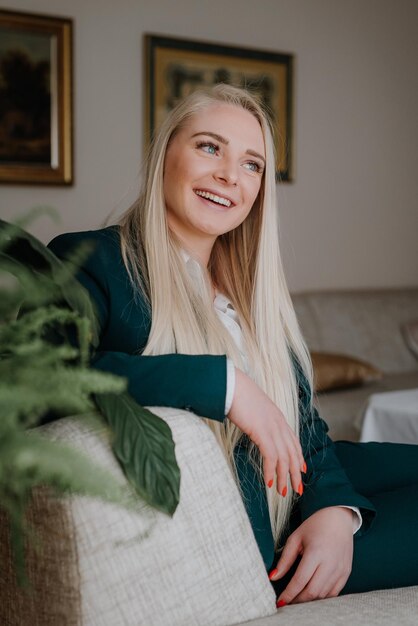 Foto portret van een glimlachende jonge vrouw die thuis zit