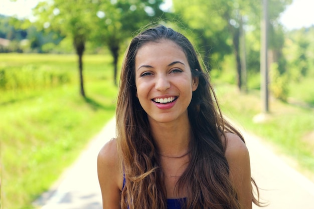 Portret van een glimlachende jonge vrouw in het park