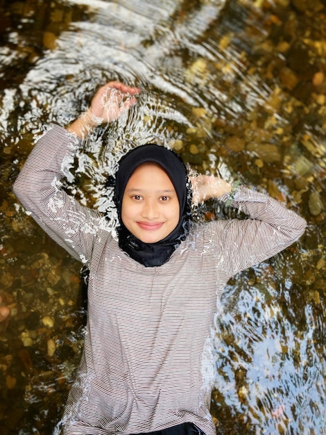 Foto portret van een glimlachende jonge vrouw in het water