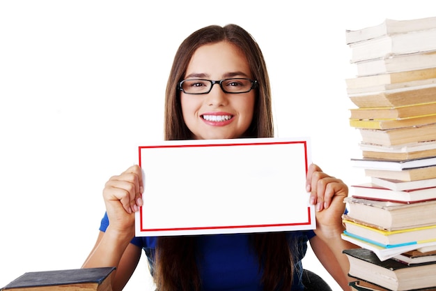 Foto portret van een glimlachende jonge vrouw met een bordje op een witte achtergrond