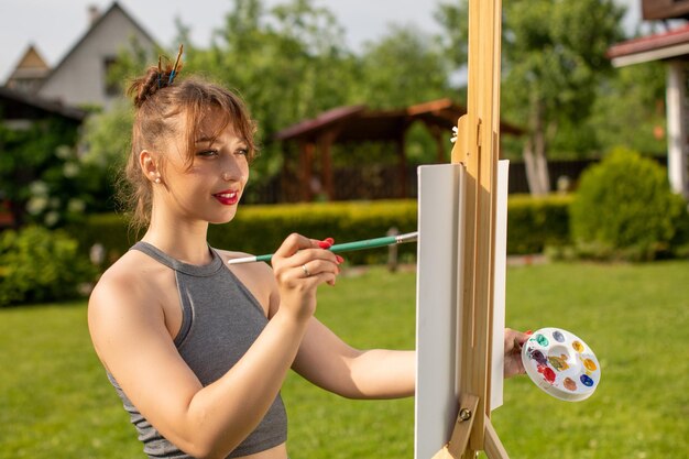 Foto portret van een glimlachende jonge vrouw met een camera