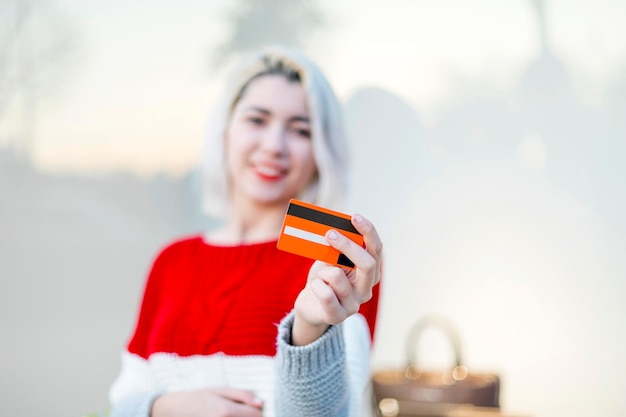 Foto portret van een glimlachende jonge vrouw met een mobiele telefoon