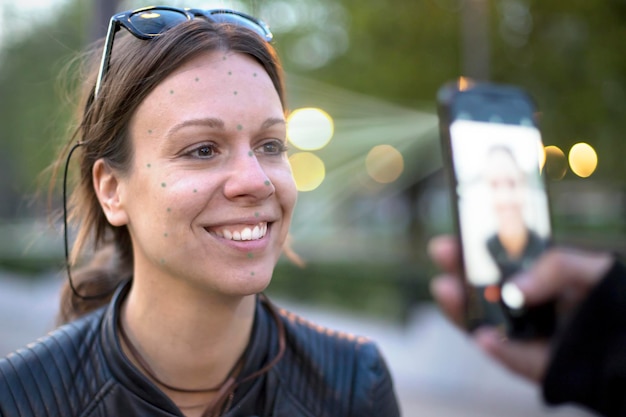 Foto portret van een glimlachende jonge vrouw met een mobiele telefoon