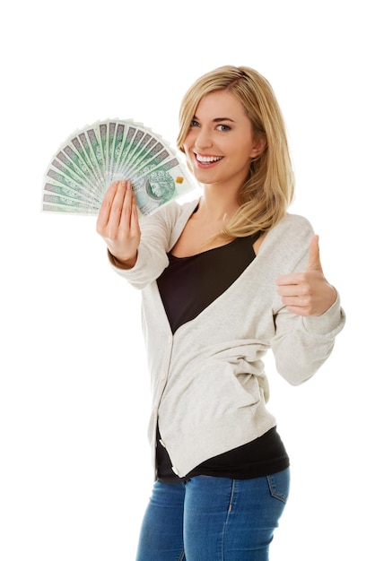 Portret van een glimlachende jonge vrouw met papiergeld op een witte achtergrond