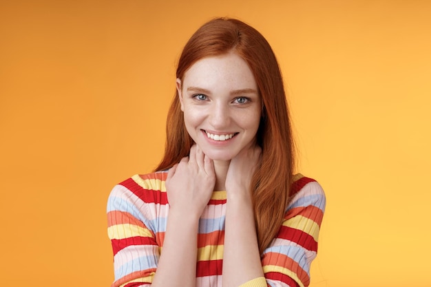 Foto portret van een glimlachende jonge vrouw op een gele achtergrond