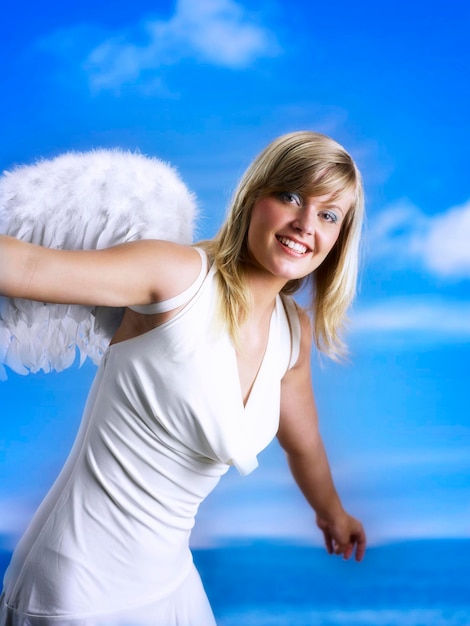 Foto portret van een glimlachende jonge vrouw tegen de blauwe hemel