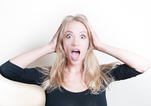 Foto portret van een glimlachende jonge vrouw tegen een witte achtergrond