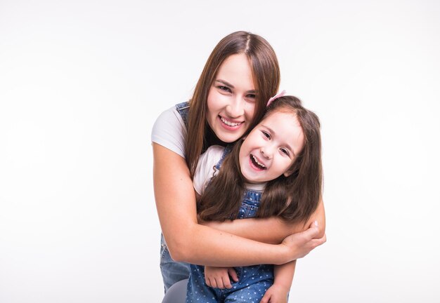 Portret van een glimlachende jonge vrouw tegen een witte achtergrond