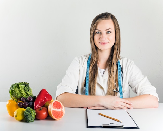 Foto portret van een glimlachende jonge vrouwelijke diëtist