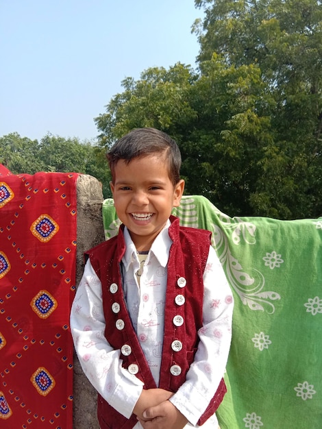 Foto portret van een glimlachende jongen die buiten staat