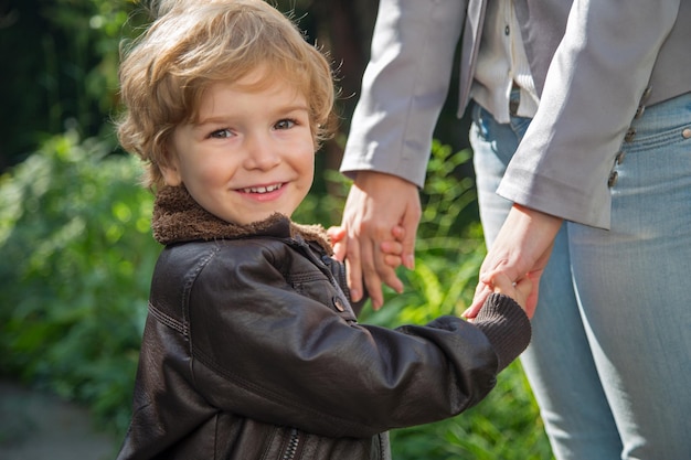 Portret van een glimlachende jongen die met zijn moeder buiten staat