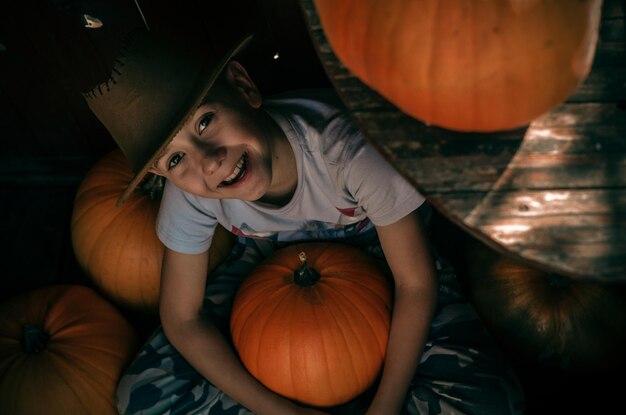 Portret van een glimlachende jongen met een pompoen tijdens Halloween