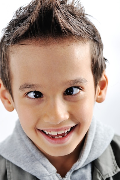 Portret van een glimlachende kleine gemengde rasjongen die op witte achtergrond wordt geïsoleerd