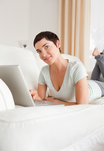 Portret van een glimlachende kortharige vrouw met een laptop