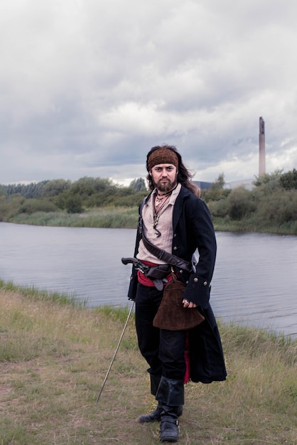 Portret van een glimlachende man die bij het water staat tegen de lucht