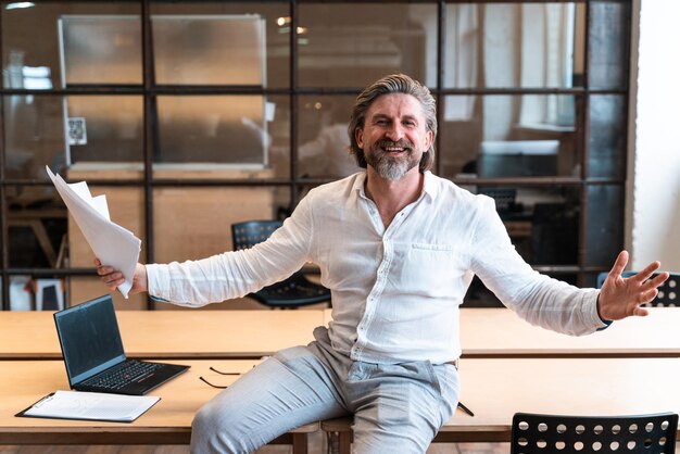 Foto portret van een glimlachende man die op tafel zit