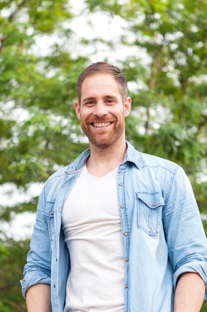 Foto portret van een glimlachende man die tegen planten staat