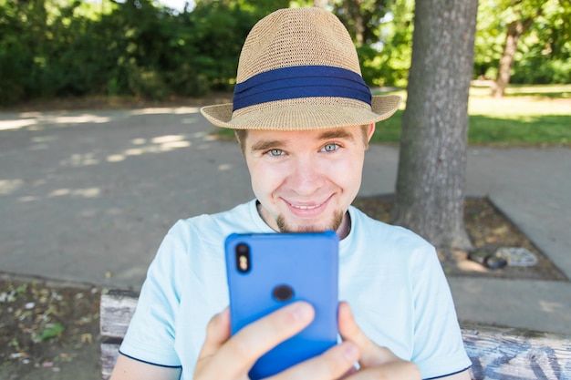 Foto portret van een glimlachende man met een mobiele telefoon