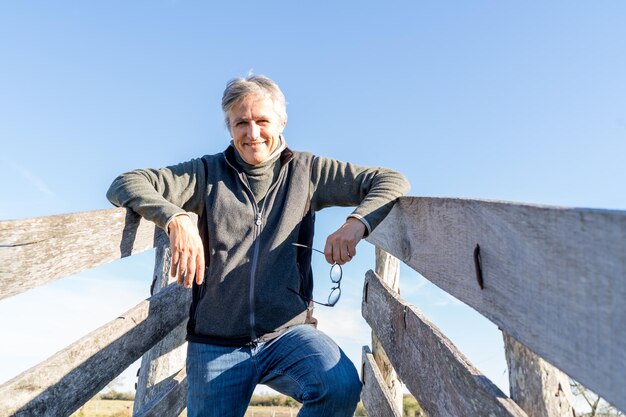 Foto portret van een glimlachende man tegen een heldere lucht