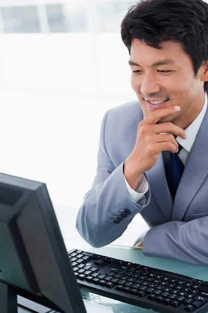 Portret van een glimlachende manager die een computer met behulp van