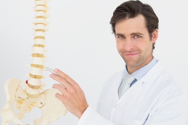 Portret van een glimlachende mannelijke arts met skelet model