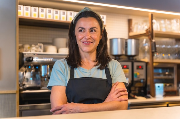 Portret van een glimlachende serveerster met de koffiemachine op de achtergrond de covid-beperkingen