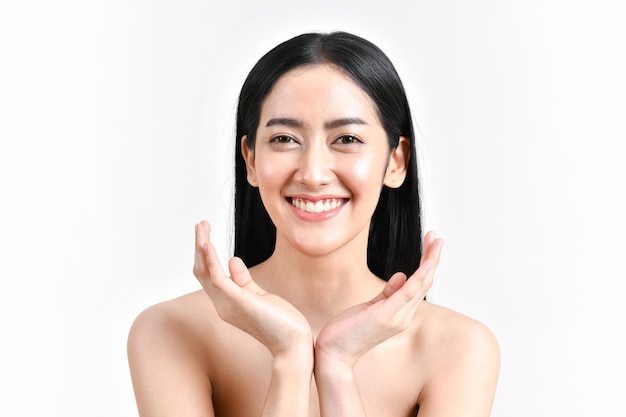 Portret van een glimlachende topless jonge vrouw die tegen een witte achtergrond gebaren maakt