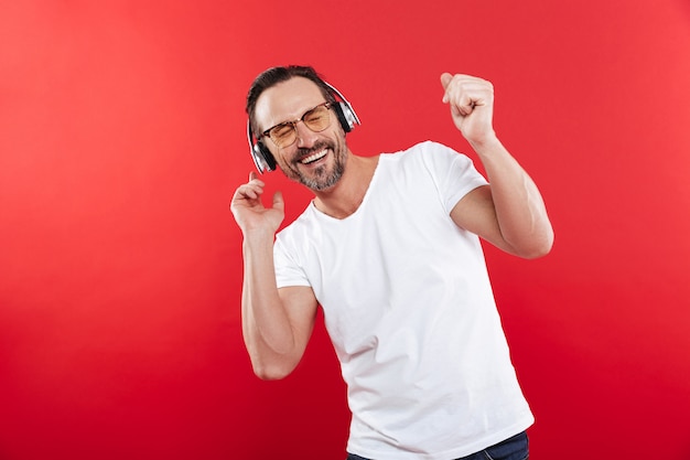 Portret van een glimlachende volwassen man luisteren naar muziek