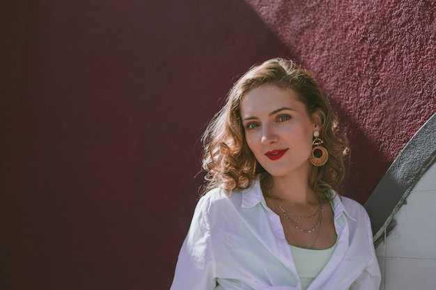 Foto portret van een glimlachende vrouw aan de muur