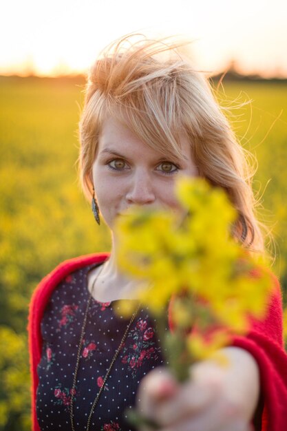 Portret van een glimlachende vrouw die bloemen geeft