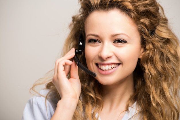 Portret van een glimlachende vrouw die een hoofdtelefoon draagt