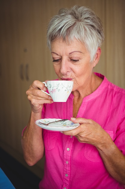 Portret van een glimlachende vrouw die een thee drinkt