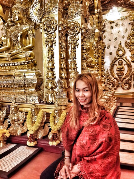 Portret van een glimlachende vrouw die in de tempel zit