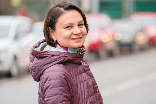 Portret van een glimlachende vrouw die op de weg in de stad staat