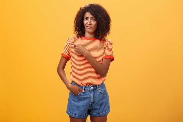 Foto portret van een glimlachende vrouw die tegen een gele achtergrond staat