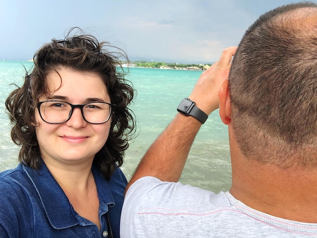 Portret van een glimlachende vrouw door een vriend op het strand