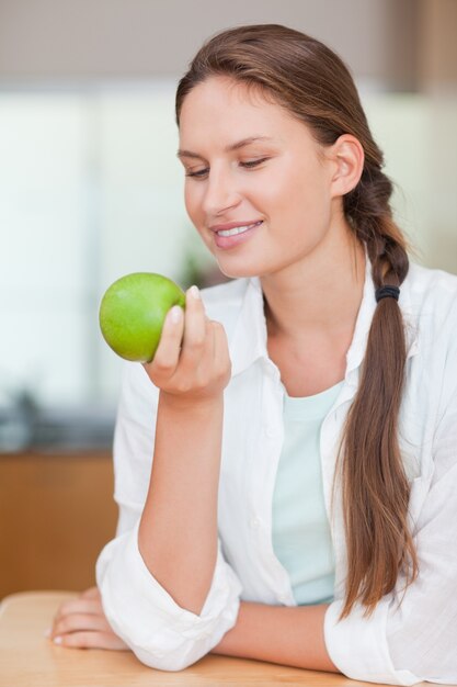 Portret van een glimlachende vrouw met een appel