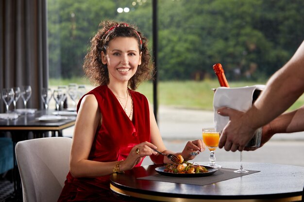 Foto portret van een glimlachende vrouw met een drankje in een restaurant