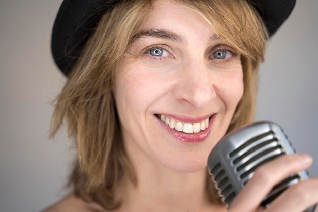 Portret van een glimlachende vrouw met een microfoon