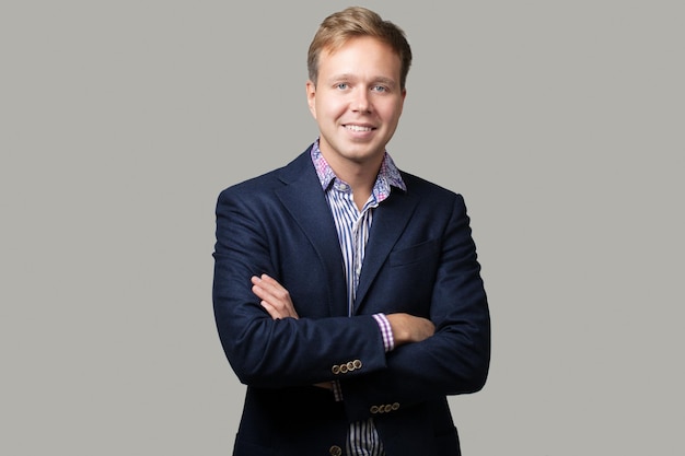 Portret van een glimlachende zakenman op een grijze achtergrond