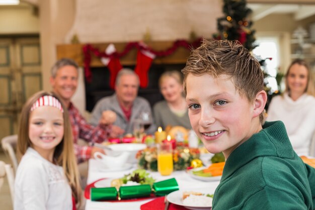 Portret van een glimlachende zoon met zijn familie achter hem