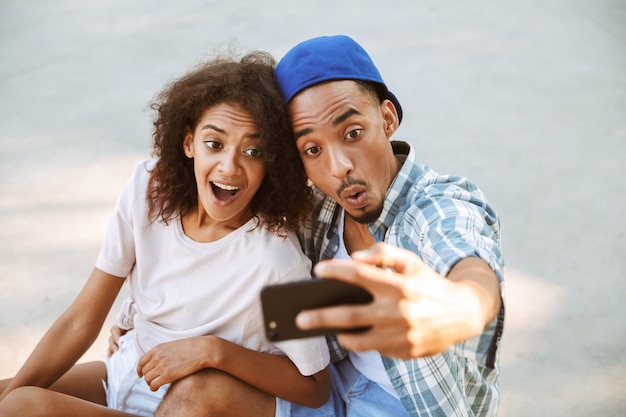 Portret van een grappig jong Afrikaans paar dat een selfie neemt