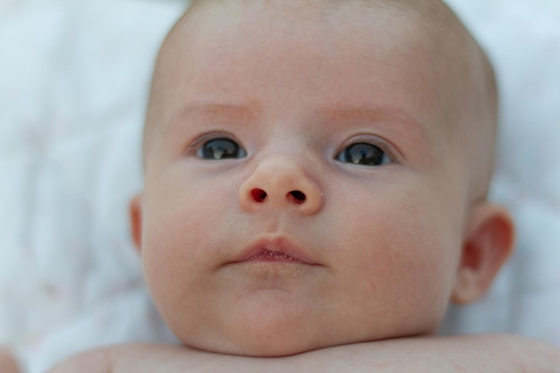 portret van een grappige blanke pasgeboren baby kijkt naar de camera