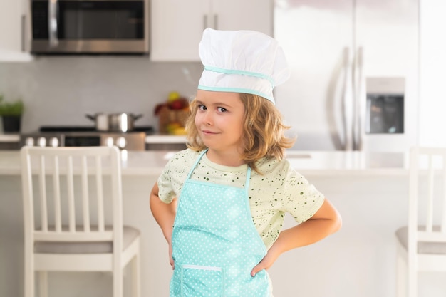 Portret van een grappige kindchef-kok in de keuken Kid chef-kok leert hoe je een cake maakt in de thuiskeuken Kind maakt lekker lekker