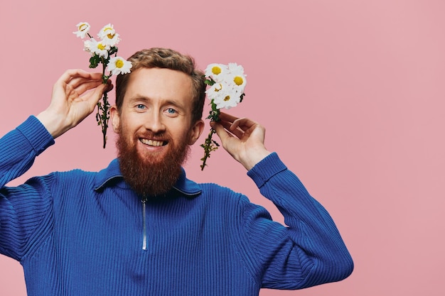 Portret van een grappige man die lacht met een boeket bloemen madeliefjes op roze geïsoleerde achtergrond kopieerplaats Concept vakantie en gefeliciteerd Valentine39s Day Women39s Day