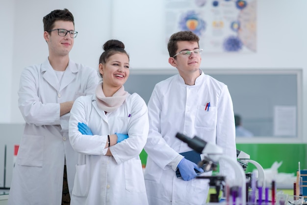 portret van een groep jonge medische studenten die samen in het scheikundelaboratorium staan, teamwork door student binnenshuis