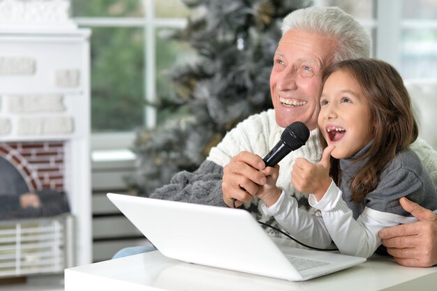 Foto portret van een grootvader en een kind die karaoke zingen